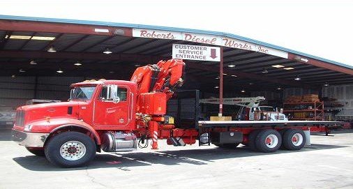 A crane truck at the customer service entrance of the Robert's Diesel Works shop in Orlando